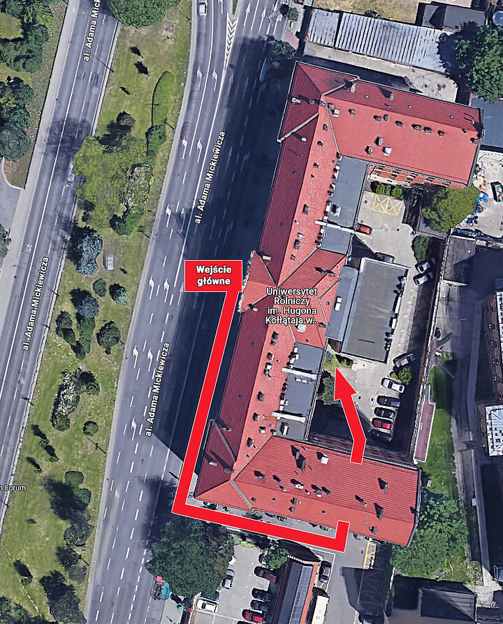 Zdjęcie lotnicze przedstawia obszar budynku z zaznaczoną przy pomocy czerwonej strzałki drogą dla osób poruszających się na wózkach.