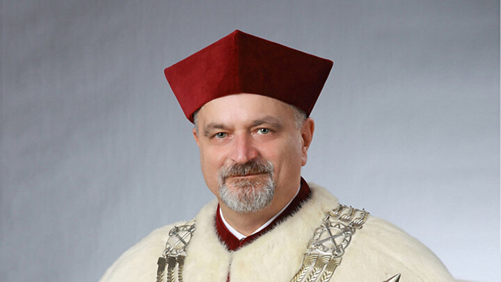 Mężczyzna w bordowym birecie i todze z kołnierzem z gronostajów